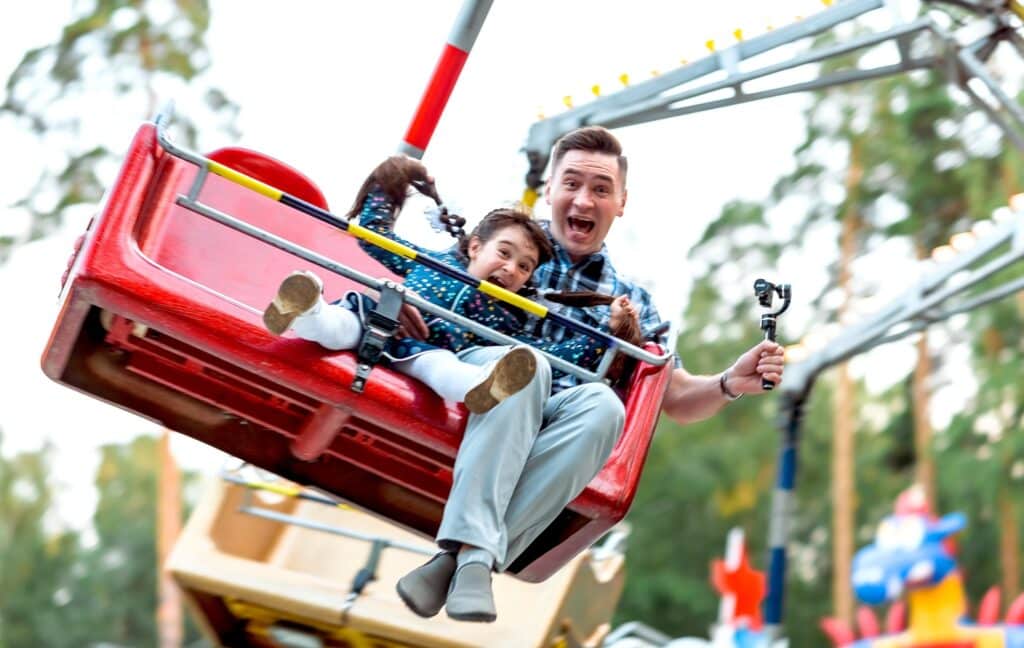 man and child on ride at theme park